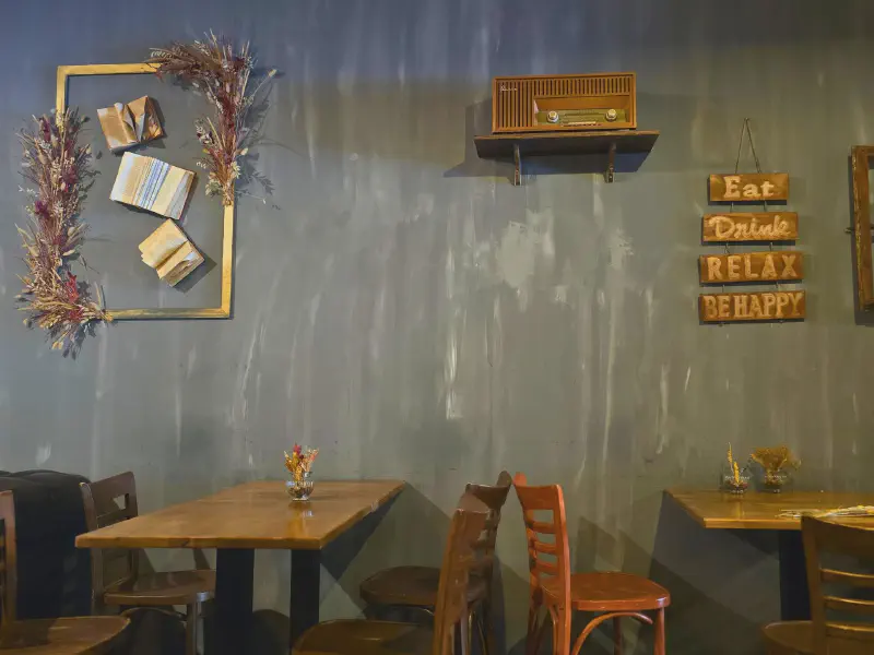 Café interior with wooden tables and an eat-drink-relax sign