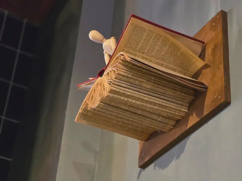Folded book as wall art with a wooden artist's mannequin