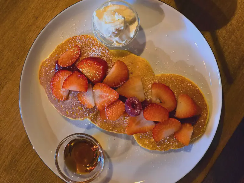 Pancakes with strawberries, mascarpone, and maple syrup from above