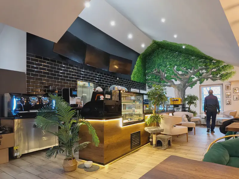 Innenansicht des Café Katzenwald mit Theke und Baum-Wandmalerei