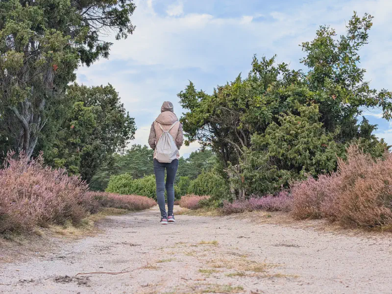 Gina walking the sandy path with her backpack