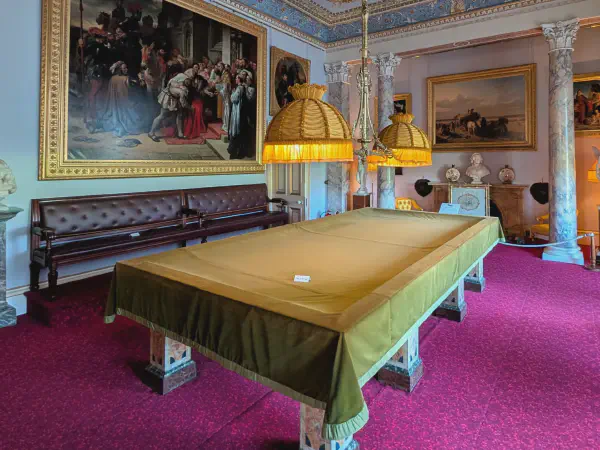 Ein großer Billiartisch vor einem Gemälde