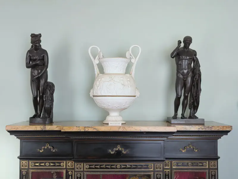Zwei Statuen mit einer Vase in der Mitte